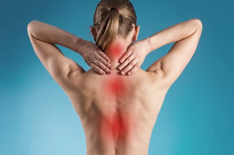 Blonde Frau mit rot markierten Rückenschmerzen greift sich an den Nacken